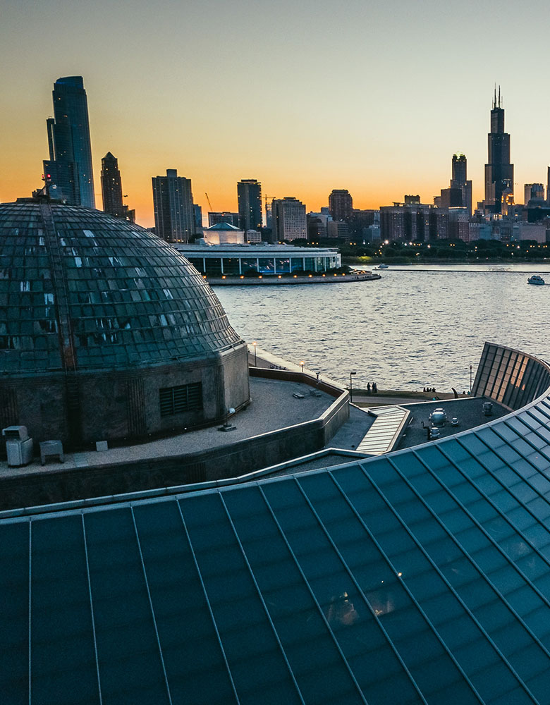 Aerial photography — Adler Planetarium dome and Chicago skyline at dusk