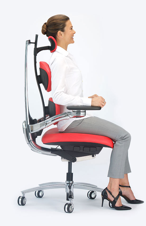 Product photography — woman seated in profile on a red MUUV ergonomic chair
